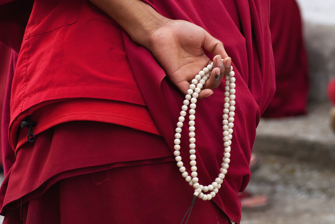 India,North Sikkim,Detail of Buddhist Monk holding prayer beads during a debating session at Rumtek Monastery,Rumtek Monastery