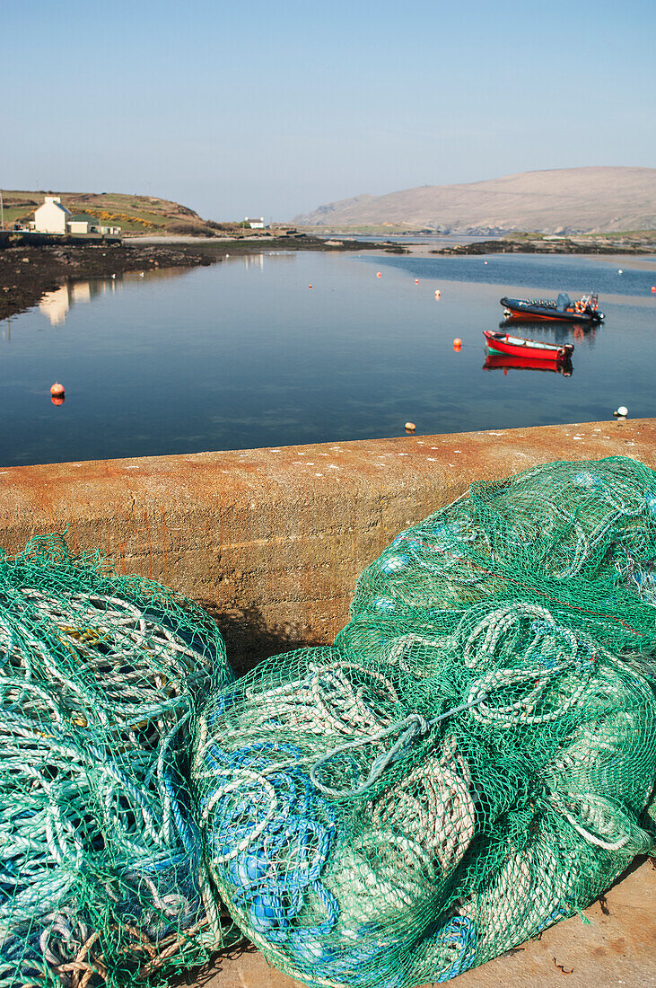 UK,Irland,County Kerry,Iveragh Peninsula,Portmagee,Netze und Seile am Ufer und Boote beim Anlegen im Hafen