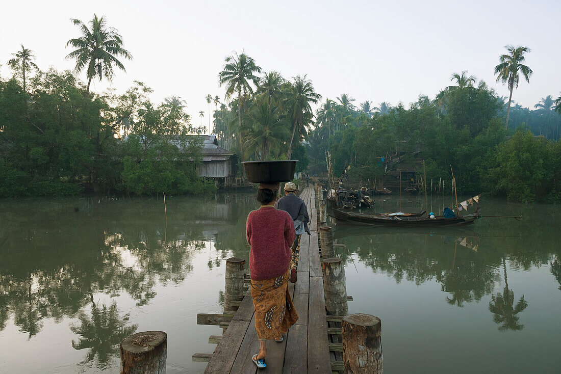 Myanmar (Burma),Irrawaddyi division,Women crossing wooden bridge over river,Nag Yoke kaung village