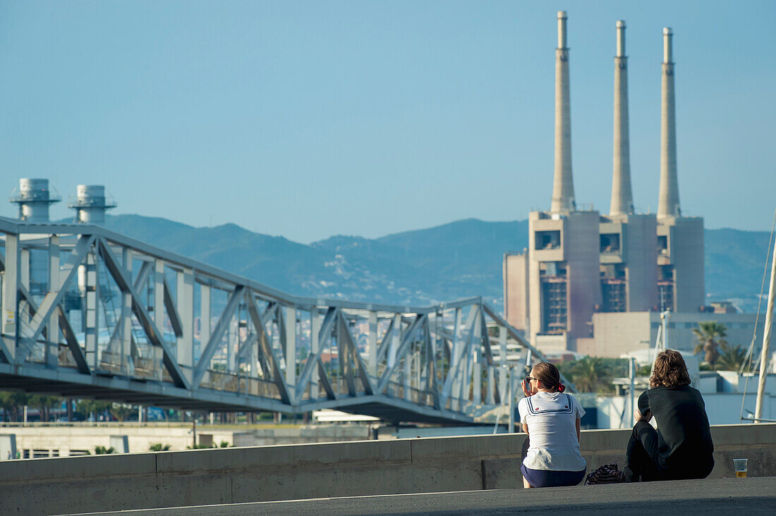 Spain,Parc del Forum,Barcelona,Festival goers enjoying the sun and views of chimneys at Primavera Sound music festival