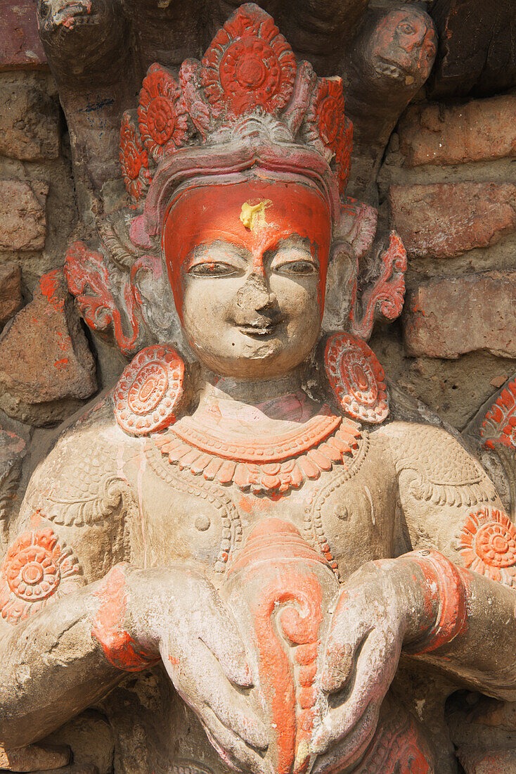 Schnitzerei von Narayan (Vishnu) hält eine Muschel an der Wand eines kleinen Tempels, Bhaktapur, Nepal