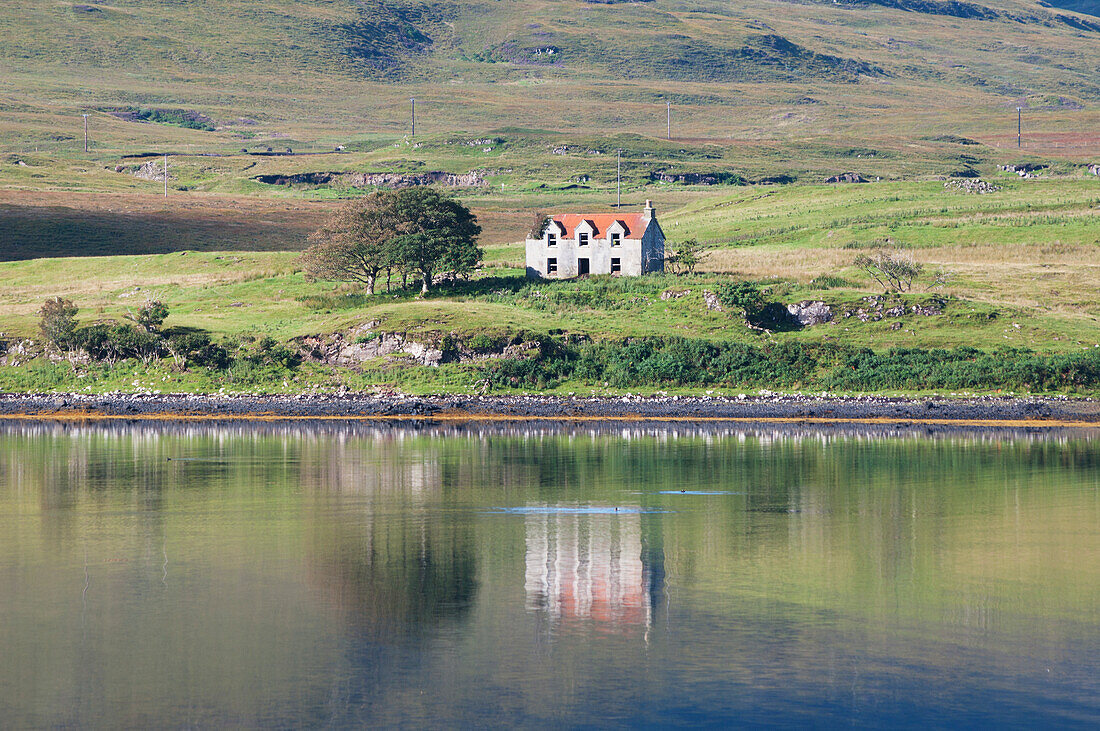Ein einsames Haus entlang der Uferlinie des Wassers, Skye, Schottland