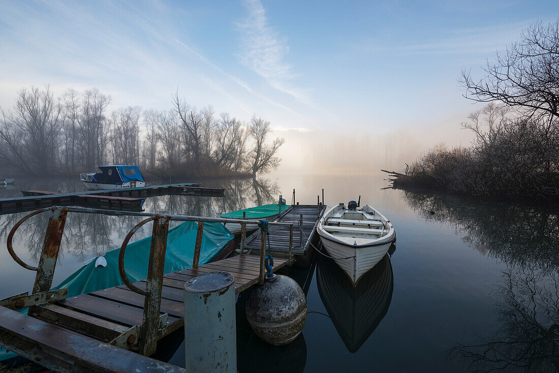 Mist Rising Over Lake Maggiore With A Canoe Tethered To A Dock,Locarno,Ticino,Switzerland