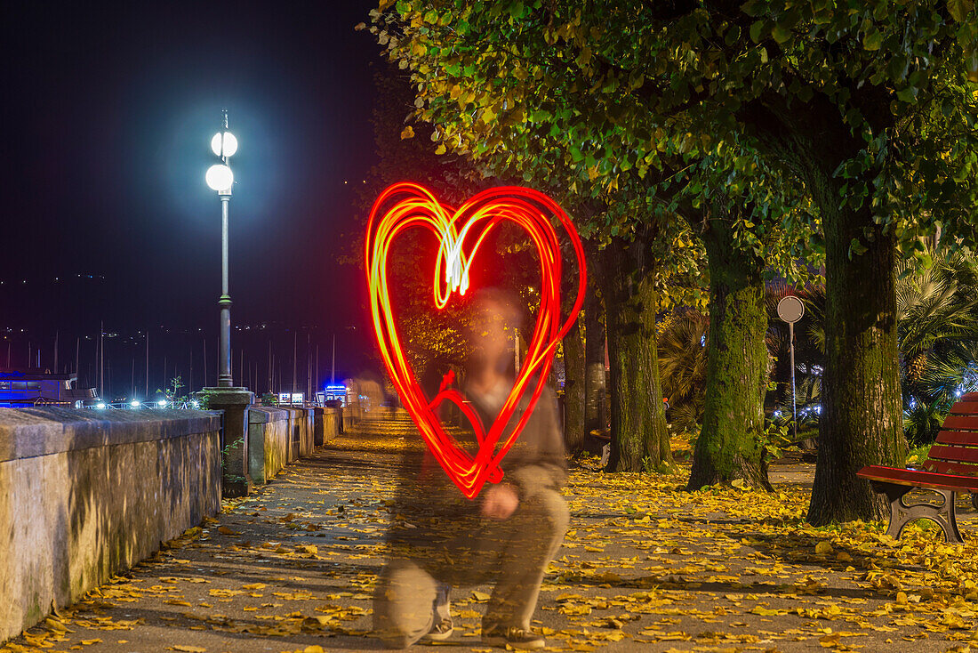 A Man Drawing A Red Glowing Heart Shape In The Air,Locarno,Ticino,Switzerland