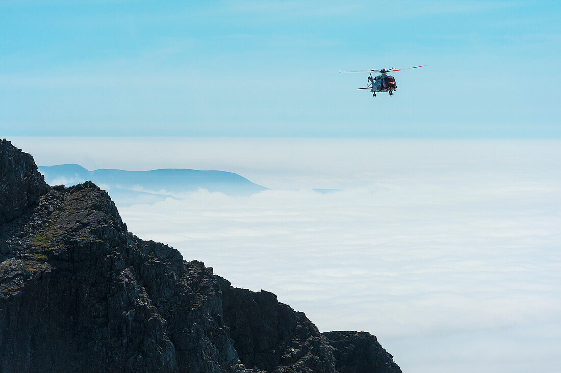 Coastguard Rescue Helicopter Coming In Above Clouds Beside Ridge In The Black Cuillin,Isle Of Skye,Scotland