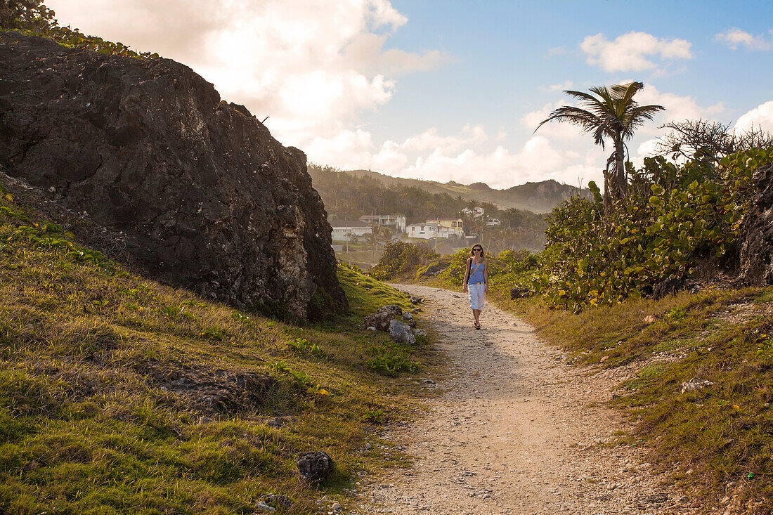 Blick auf eine Frau, die auf einem Küstenweg in Bathsheba spazieren geht, Bathsheba, Barbados, Karibik