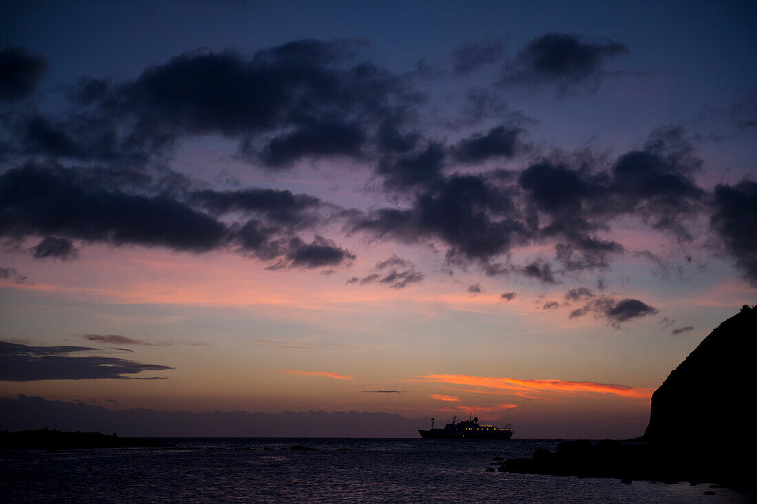 Silhouette of a cruise ship at sunset near San Cristobal Island in Galapagos Islands National Park,San Cristobal Island,Galapagos Islands,Ecuador