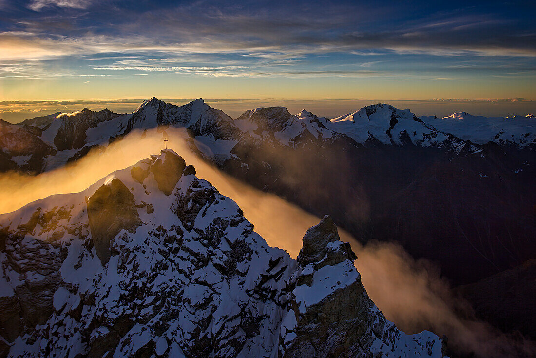 Summit cross surrounded by morning fog in the Alps,Zermatt,Switzerland