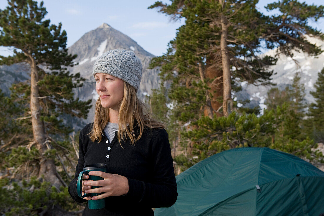 Frau trinkt Kaffee auf einem Campingplatz am Sixty Lake Basin im Kings Canyon National Park, Kalifornien, Vereinigte Staaten von Amerika