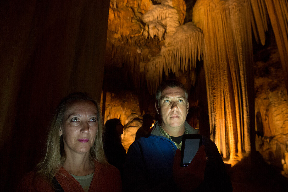 Man and woman illuminated as they explore the Luray Caverns,Luray,Virginia,United States of America
