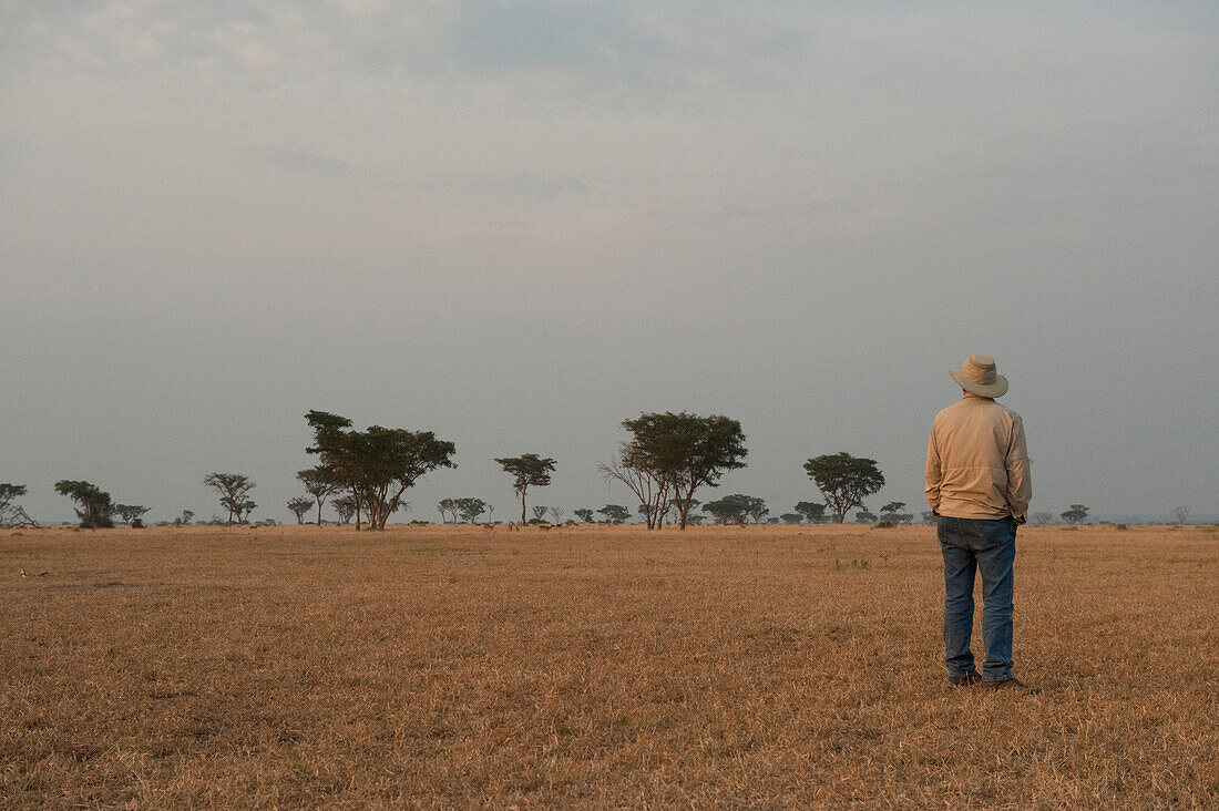 Man stands alone admiring the scenery in Queen Elizabeth National Park in Uganda,Africa,Uganda