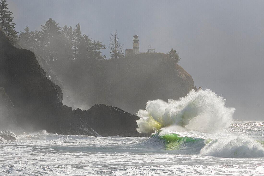 Morgennebel verstärkt die dramatische Schönheit der an die Klippen krachenden Wellen am Cape Disappointment-Leuchtturm an der Mündung des Columbia River im Südwesten Washingtons, Washington, Vereinigte Staaten von Amerika