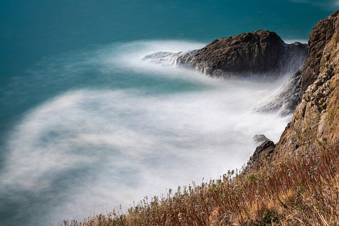 Langzeitbelichtung von schäumenden Wellen, die gegen die Klippen am Cape Disappointment an der Mündung des Columbia River im Südwesten Washingtons, Washington, Vereinigte Staaten von Amerika, schlagen