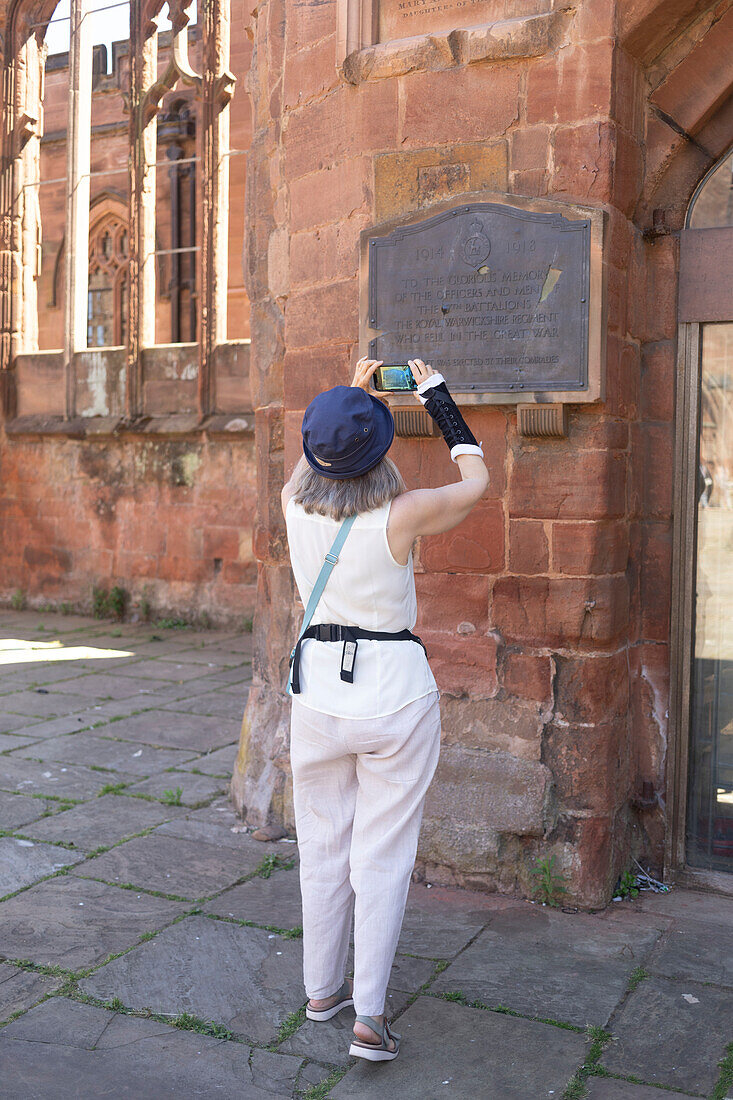 Mature woman uses her smart phone while exploring a historic site,United Kingdom