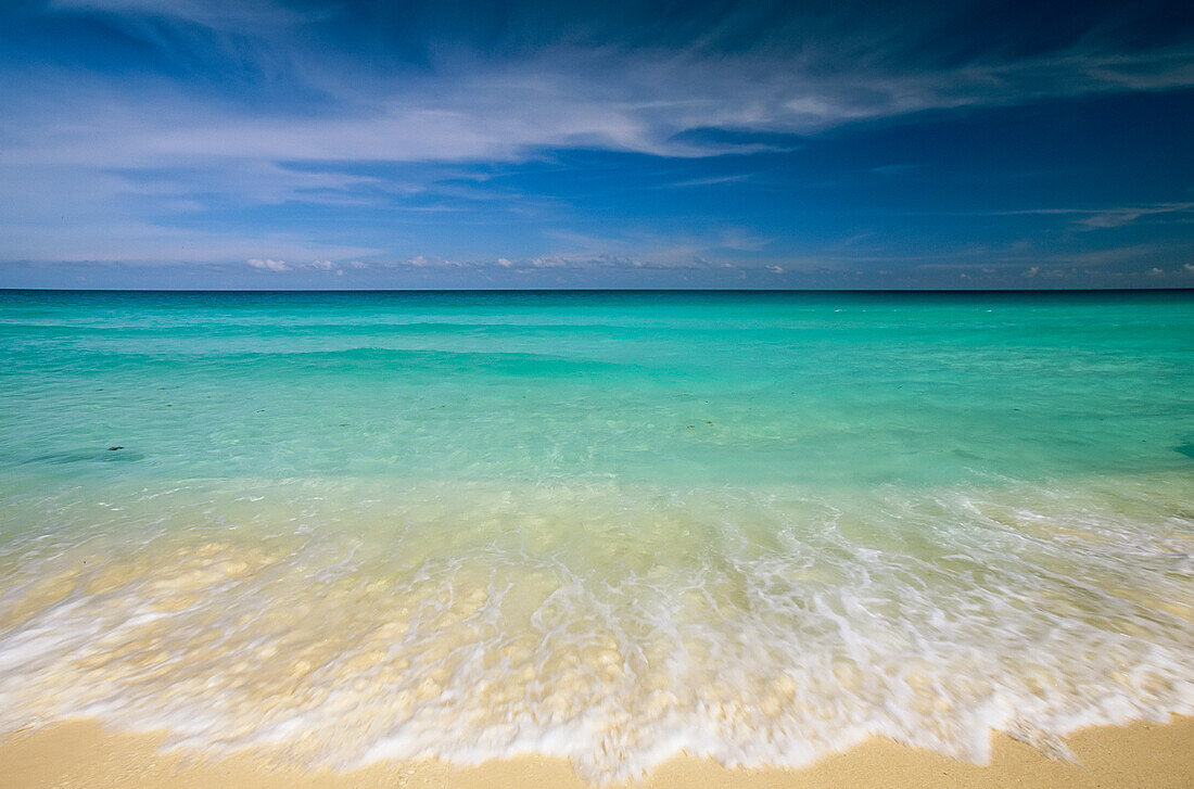 Clear blue water and wispy clouds along the beach at Cancun,Cancun,Mexico