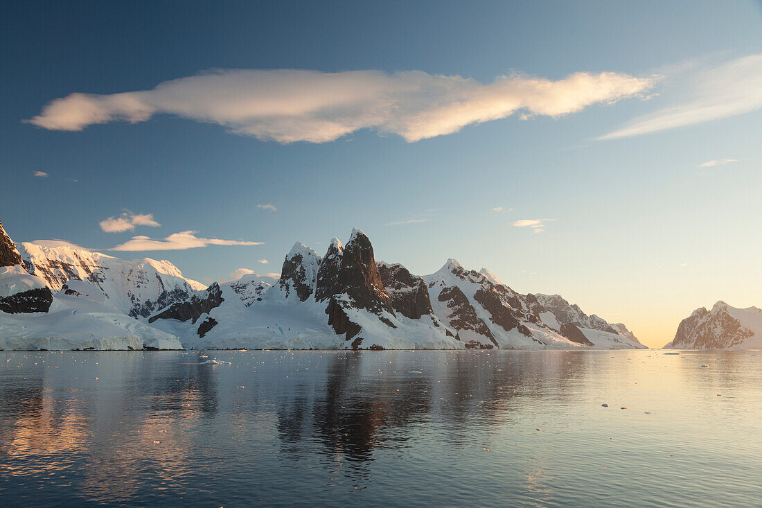 Reflections of cliffs and mountains in the Lemaire Channel at sunset,Antarctica