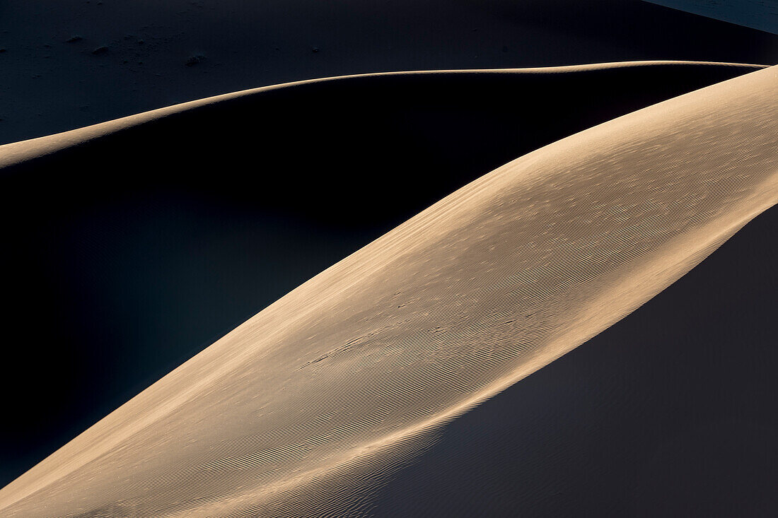 Das Nachmittagslicht wirft lange Schatten auf die Sanddünen im Namib-Naukluft Park, Sossusvlei, Namibia