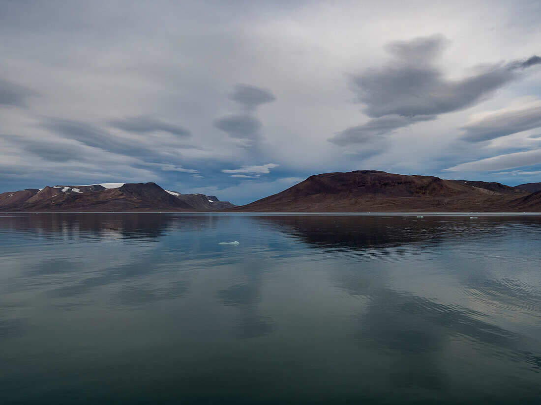 Bewölkter Himmel über Spitzbergen und das ruhige Wasser des Sunds, Spitzbergen, Svalbard, Norwegen