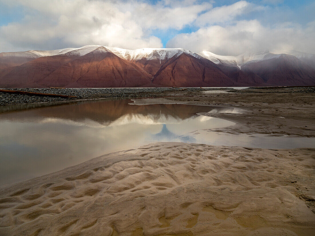 Gezeitentümpel spiegelt eine entfernte Gebirgskette wider, Spitzbergen, Svalbard, Norwegen
