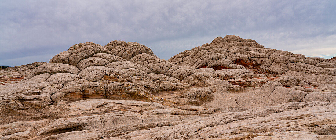 Scenic view of rocky hills against a cloudy sky form part of the alien landscape of amazing lines,contours and shapes in the wondrous area known as White Pocket,situated in Arizona,Arizona,United States of America