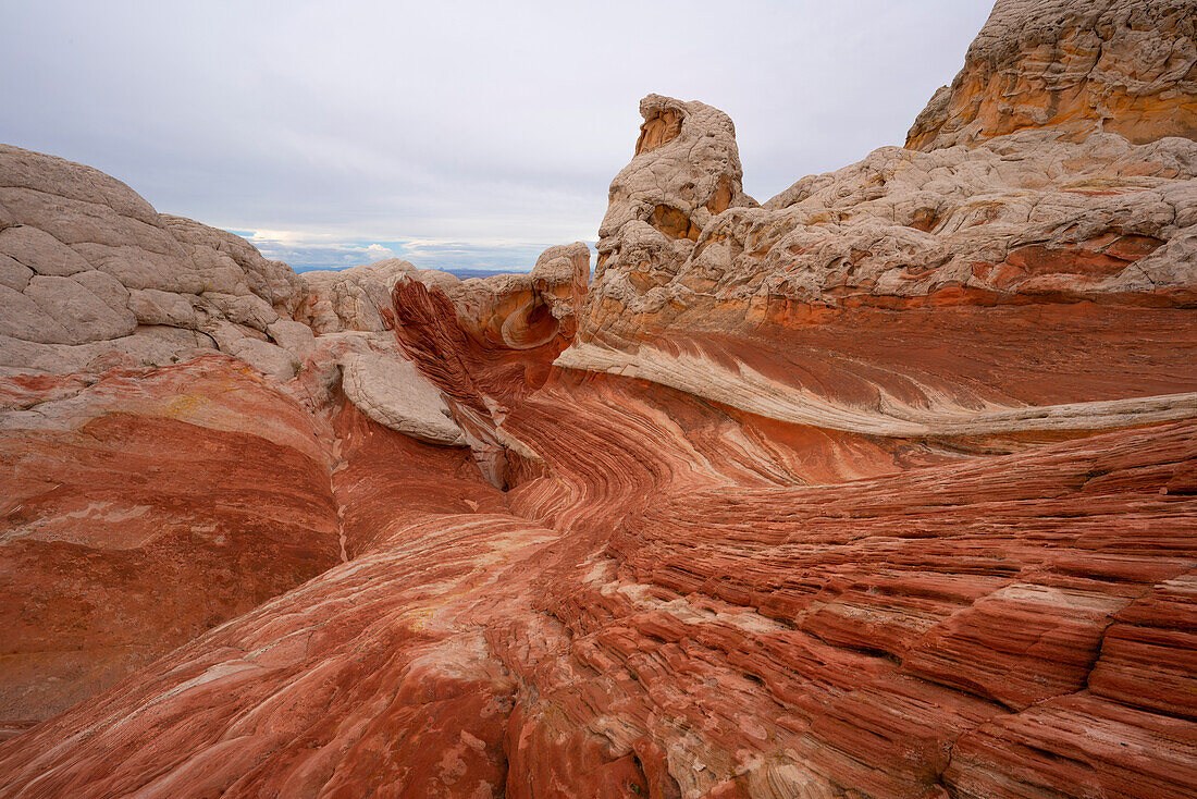 Landschaftliche Ansicht von wirbelnden Mustern und hügeligen Felsformationen unter einem bewölkten Himmel, die Teil der fremden Landschaft von erstaunlichen Linien, Konturen und Formen in der wundersamen Gegend bekannt als White Pocket, in Arizona, Arizona, Vereinigte Staaten von Amerika