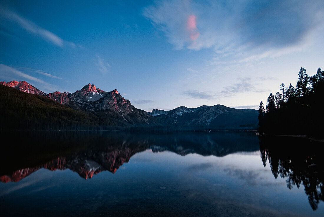 Dämmerungsansicht der Sawtooth Range, die sich im Sawtooth Lake spiegelt, Idaho, Vereinigte Staaten von Amerika