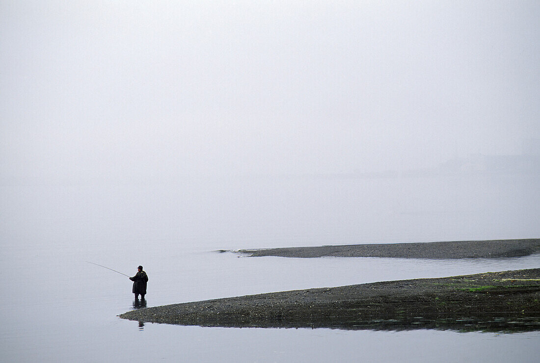 Lone fisherman fishing on a misty coast,Orleans,Cape Cod,Massachusetts,United States of America