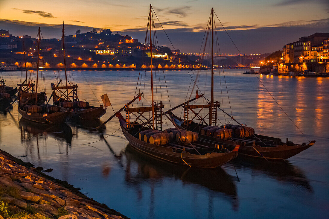 Boats carrying wine barrels in Oporto harbor at dusk,Porto,Portugal
