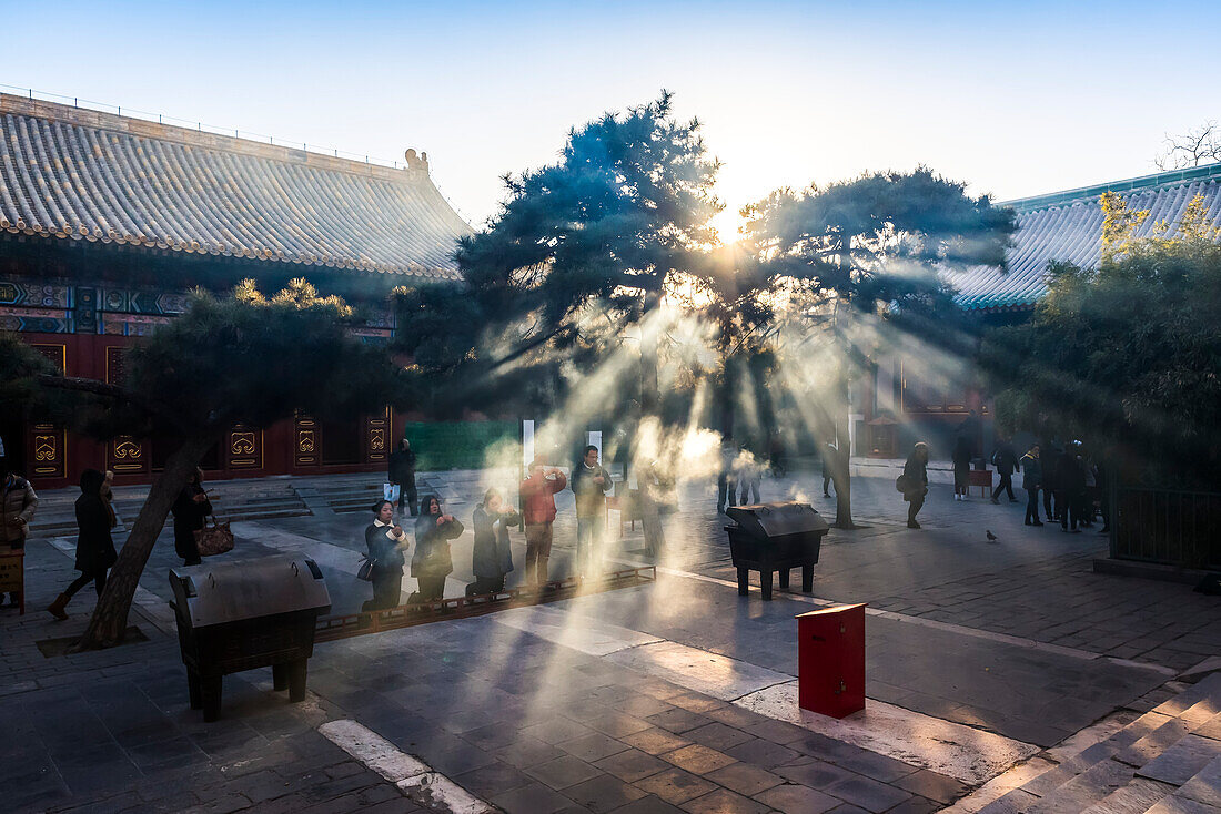 Sonnenlicht durch Rauchwolken, Lama-Tempel, Bezirk Dongcheng, Peking, China