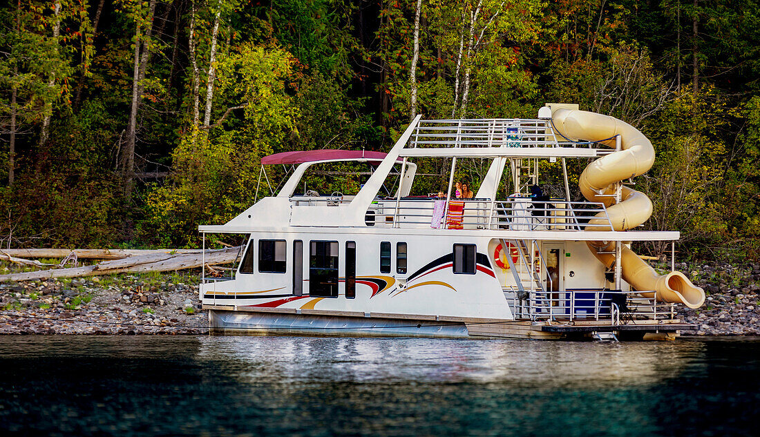 A family enjoying a houseboat vacation while parked on the shoreline of Shuswap Lake,Shuswap Lake,British Columbia,Canada