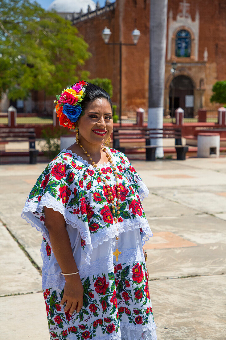 Mayan woman in traditional dress standing outside the Church of San Antonio de Padua,a former convent,Ticul,Yucatan,Mexico