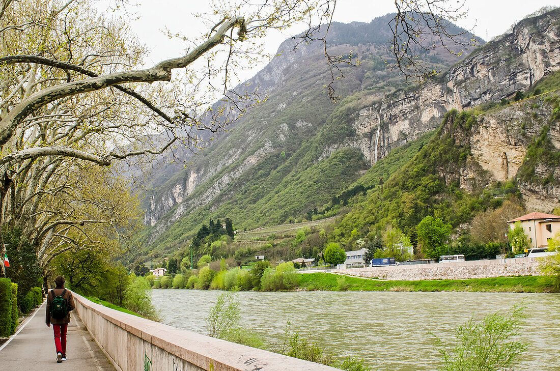 View of the Adige River with footpath and a man walking,Trento,Trentino,Italy