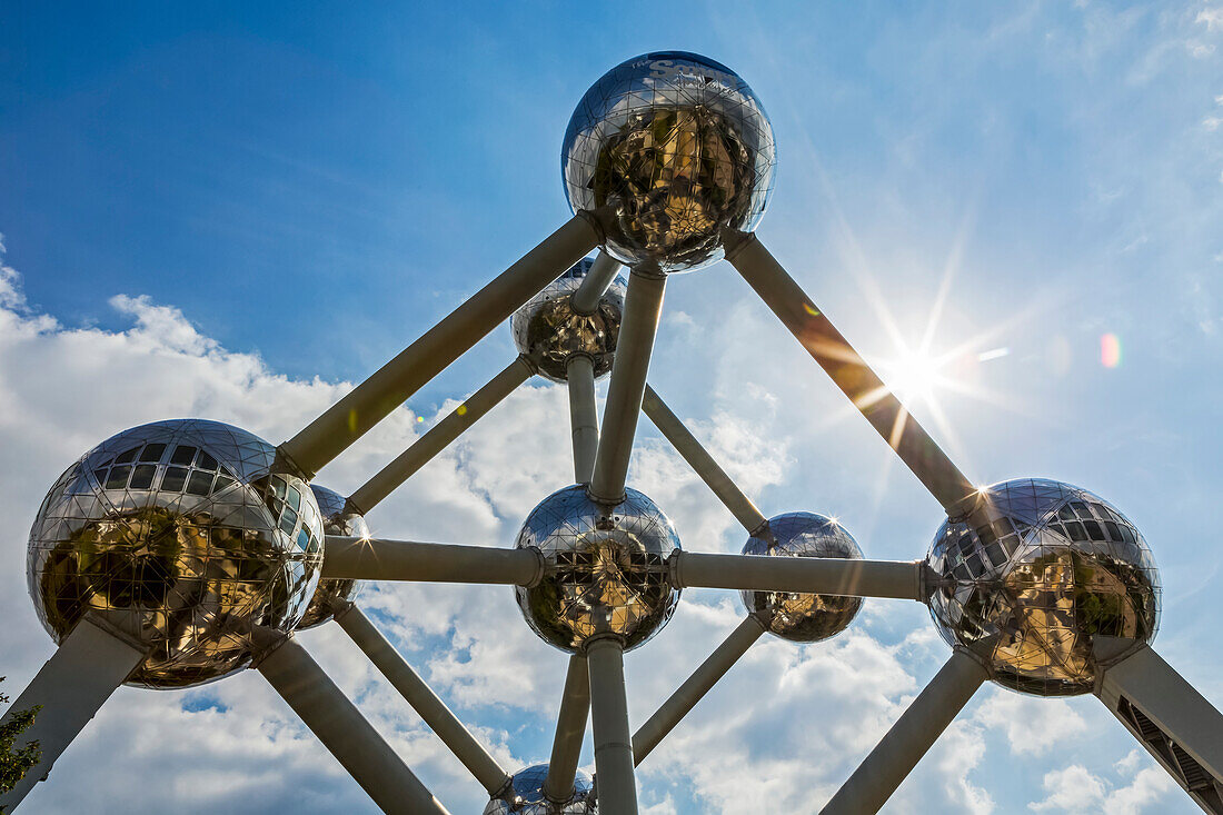 Large stainless steel art structure in the shape of an atom with blue sky and sunburst,Brussels,Belgium