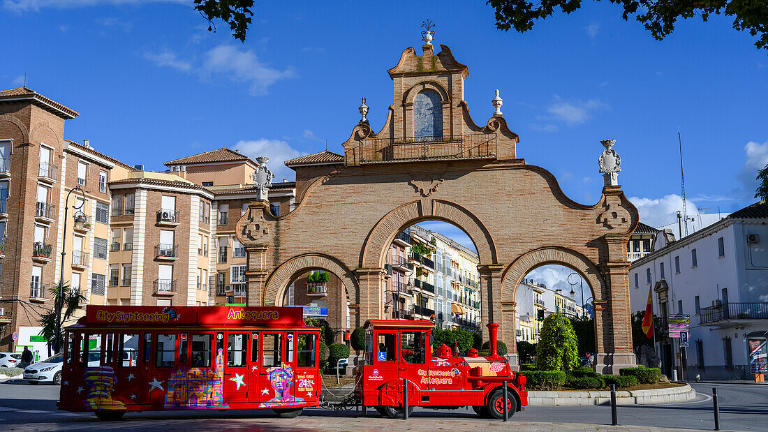 Bright red passenger vehicle as a tour train on a street in a Spanish town,Antequera,Malaga,Spain