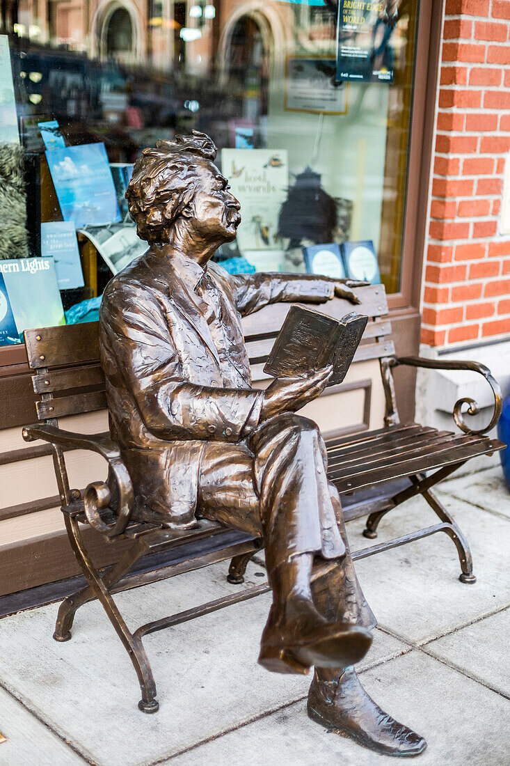 Skulptur von Mark Twain auf einer Bank beim Lesen eines Buches vor einer Buchhandlung,Fairhaven,Washington,Vereinigte Staaten von Amerika
