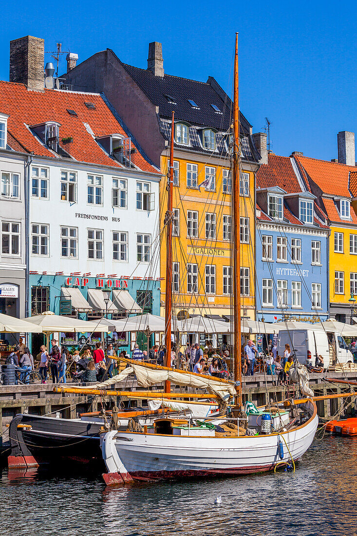 Boote und Menschen entlang des bunten Hafenviertels Nyhavn, Kopenhagen, Dänemark