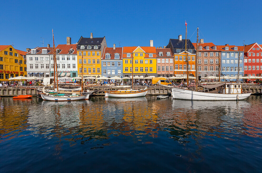 Boats and people along a colourful waterfront called Nyhavn,Copenhagen,Denmark