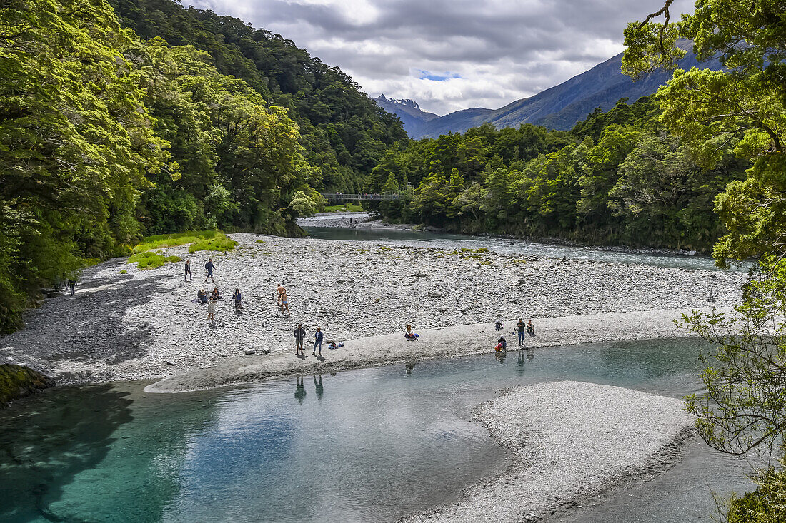 People on the beach looking at the Blue Pools of the Blue Pools Track in Mt Aspiring National Park,Wanaka,Otago Region,South Island,New Zealand