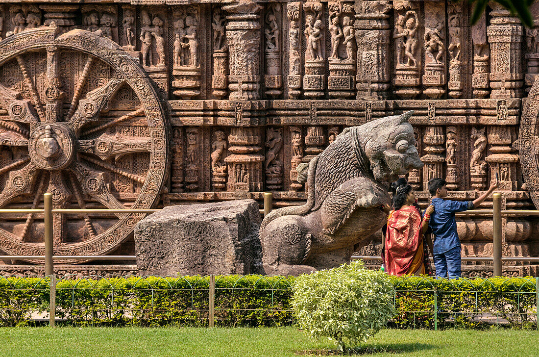 Junge Familie, die ein Selbstporträt in der Nähe einer Löwenstatue im Sonnentempel von Konark, Staat Odisha, Indien, aufnimmt