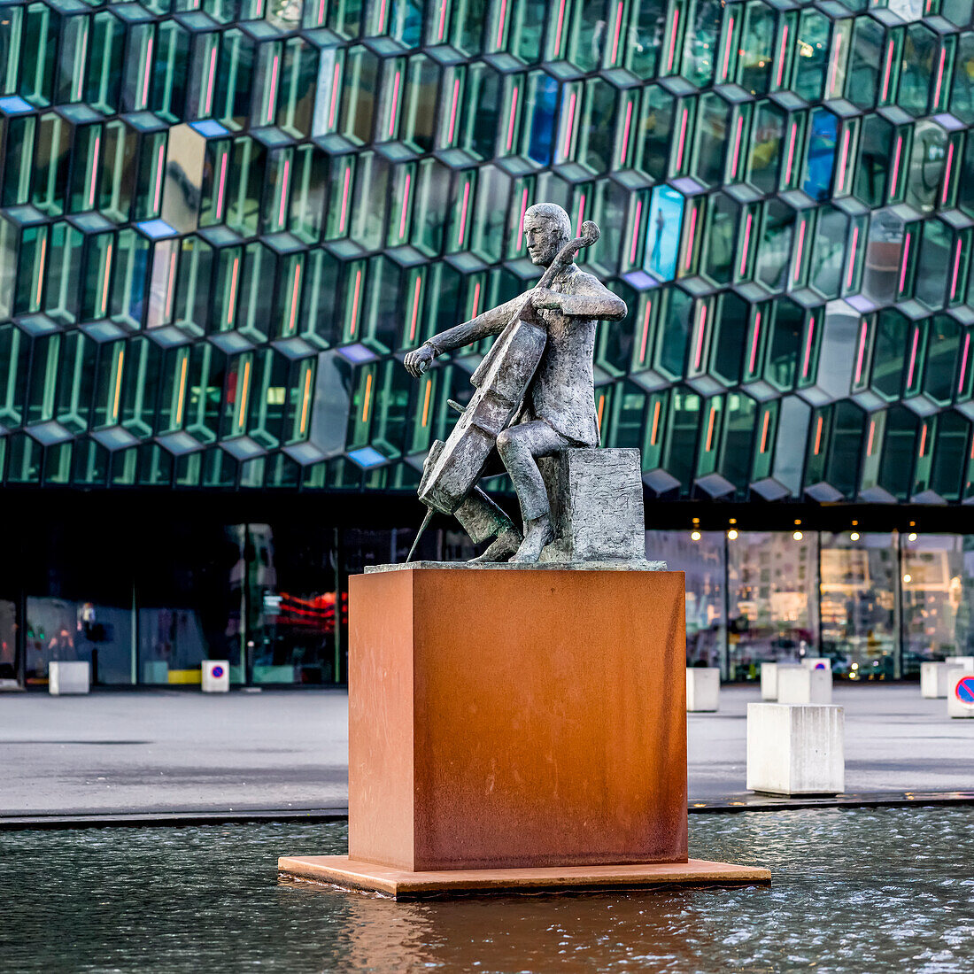 Modern glass honeycomb facade of the Harpa Concert Hall and Conference Centre,home to the National opera and symphony. Sculpture of the musician,Olof Palsdottir,in a water feature outside,Reykjavik,Reykjavik,Iceland