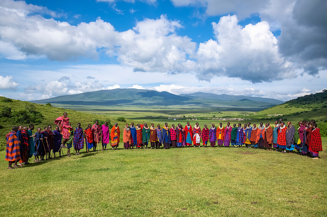 Maasai-Dorfbewohner versammeln sich zur Begrüßung und zum Tanz für eine Gruppe von Touristen im Ngorongoro-Krater-Schutzgebiet, Tansania