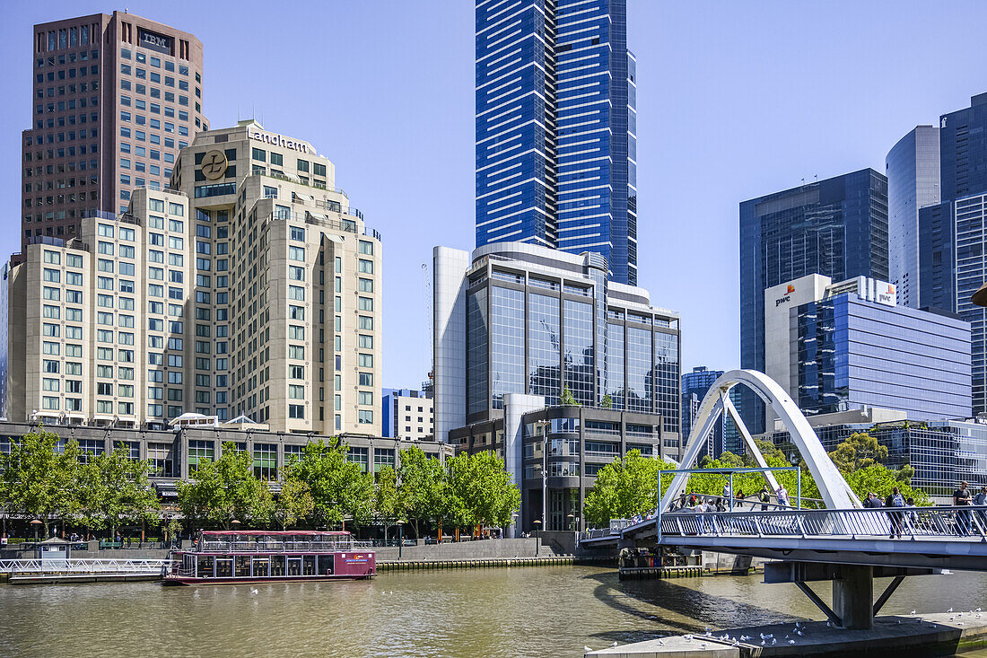 Evan Walker-Fußgängerbrücke über den Yarra River mit einem Ausflugsboot am Ufer, Melbourne, Victoria, Australien