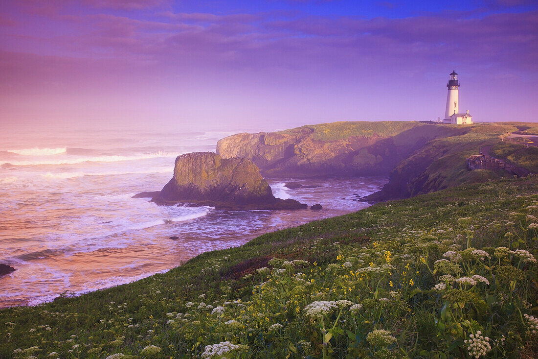 Yaquina Head Light bei Sonnenaufgang mit der an die Küste rollenden Brandung entlang der Küste von Oregon,Oregon,Vereinigte Staaten von Amerika