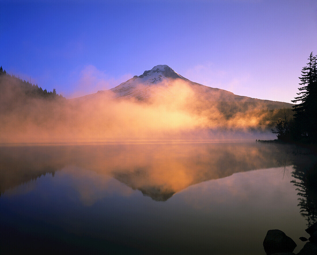 Dramatic glowing fog at sunrise over Trillium Lake with the mirror image of Mount Hood in Trillium Lake,Oregon,United States of America