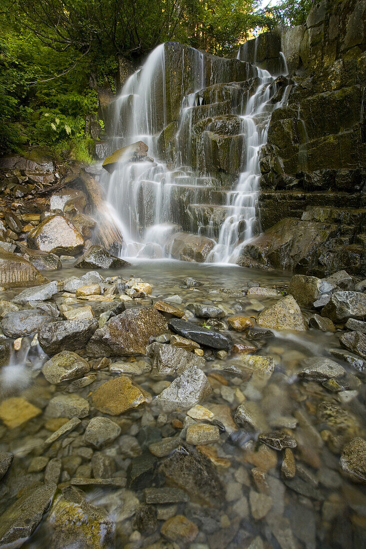 Ein Wasserfall, der über einen felsigen, zerklüfteten Abhang in einen Bach plätschert, Mount Rainier National Park,Washington,Vereinigte Staaten von Amerika