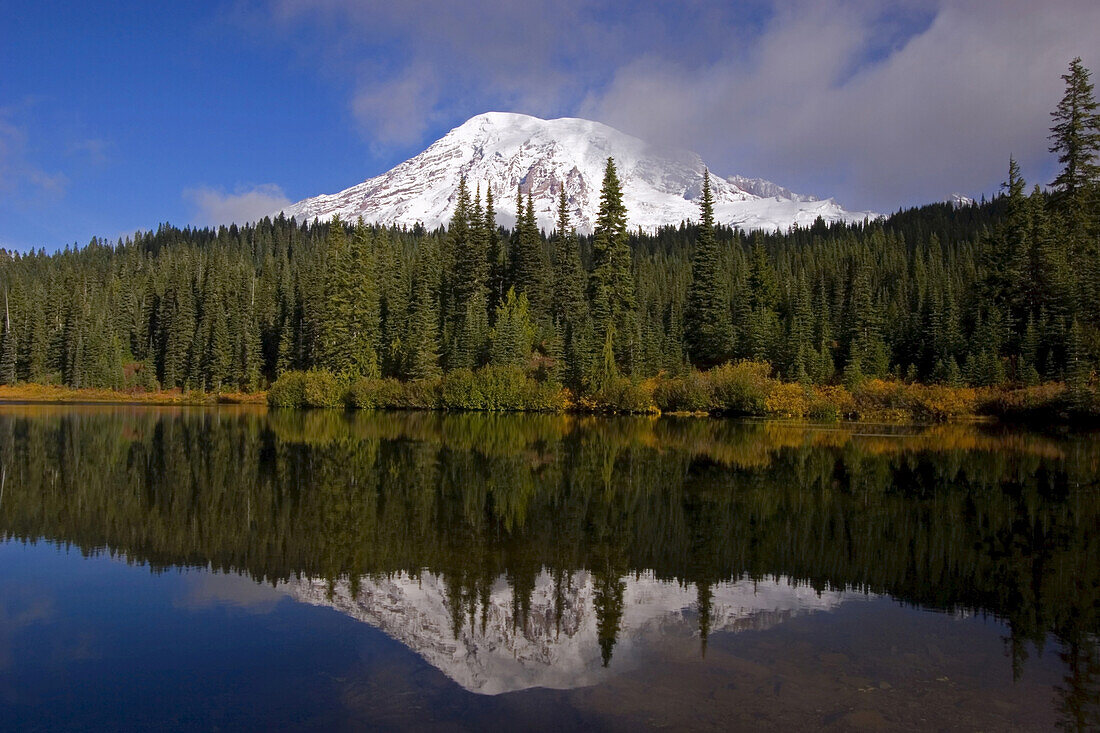 Mount Rainier and forest reflected in a tranquil lake in Mount Rainier National Park,Washington,United States of America