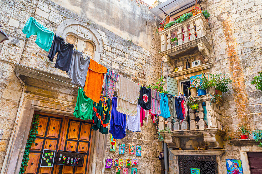 A clothesline with clothing and towels hanging to dry outside a home,Croatia