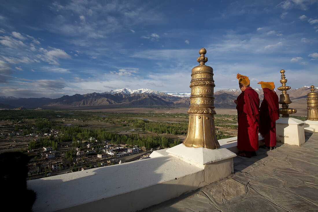 Buddhistische Mönche blasen Hörner auf dem Dach des Klosters Thikse oberhalb des Industals in den Himalaya-Bergen von Ladakh, Jammu und Kaschmir, Thiksey, Ladakh, Indien