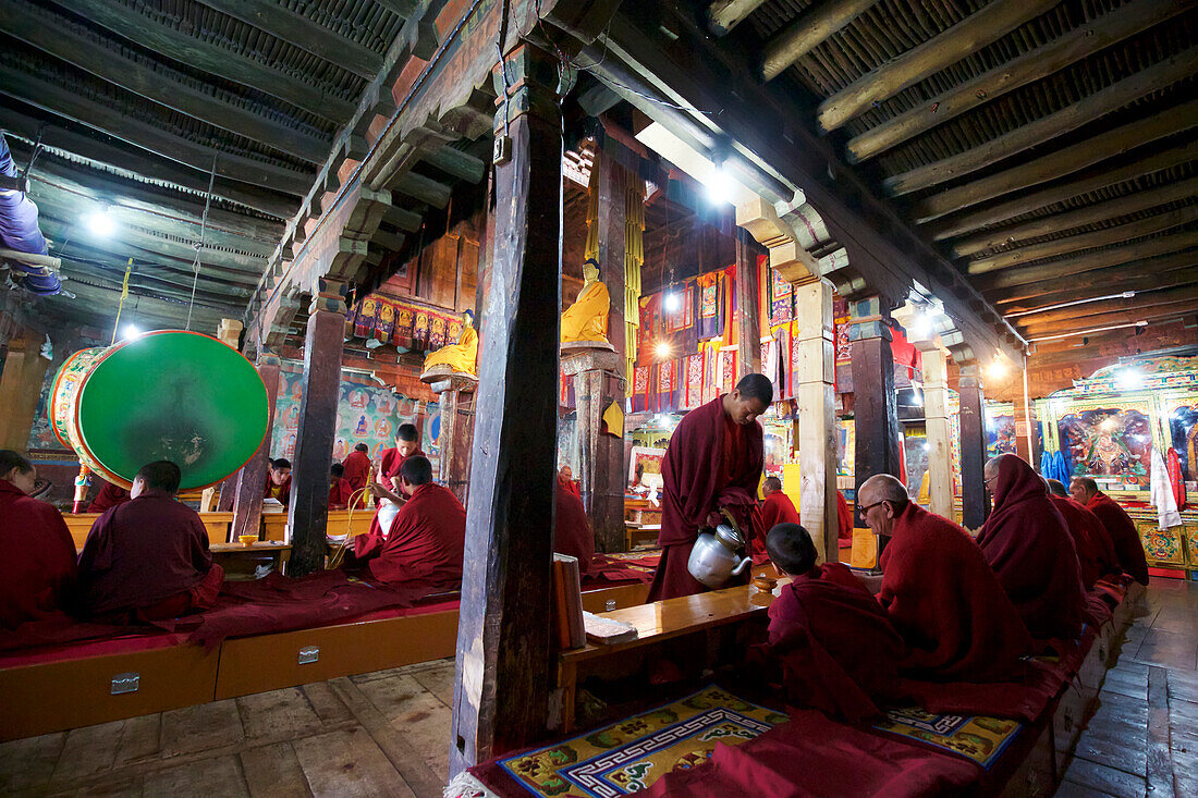 Buddhistische Mönche beim Tee in der Gebetshalle des Klosters Thikse oberhalb des Indus-Tals in den Himalaya-Bergen von Ladakh, Jammu und Kaschmir, Thiksey, Ladakh, Indien