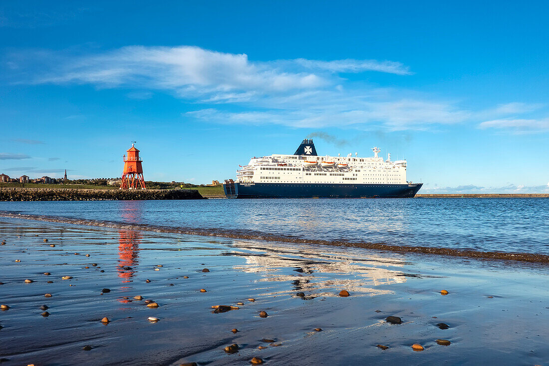 Ein Kreuzfahrtschiff passiert den Herd Groyne Lighthouse, South Shields, Tyne and Wear, England